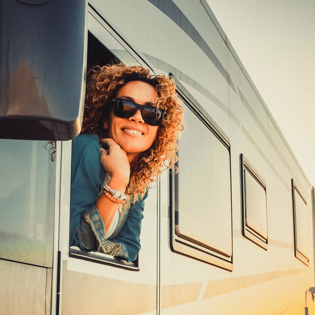 Woman smiling and looking outside while in a new RV