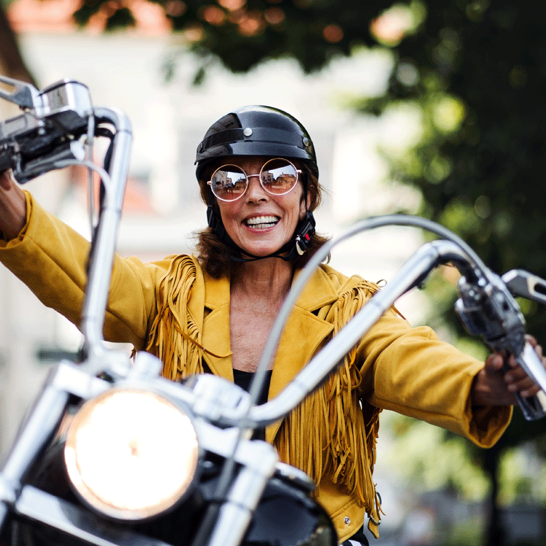 Woman smiling while riding a new motorcycle