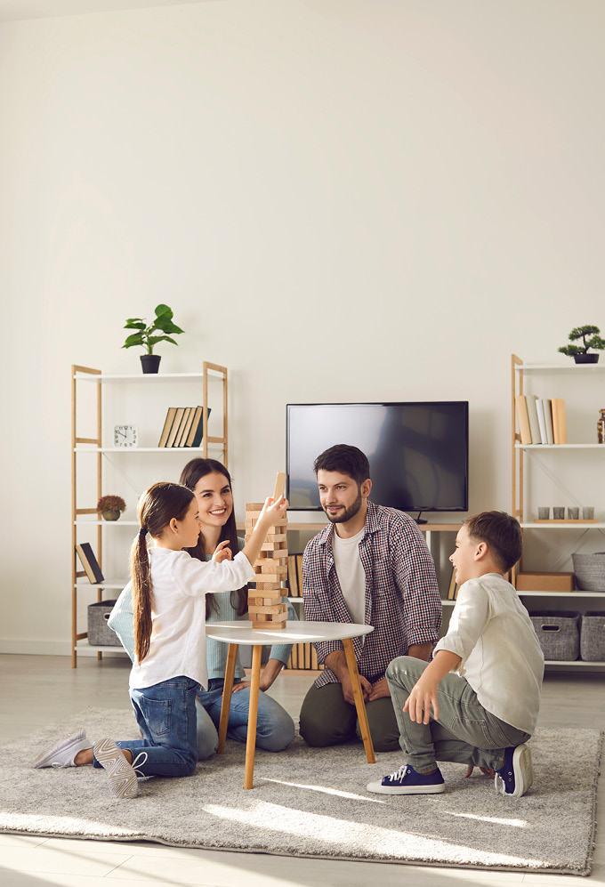 Family playing jenga on floor of living room area