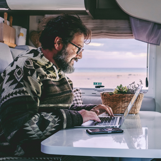 older man with beard applying for rv refinancing on a laptop