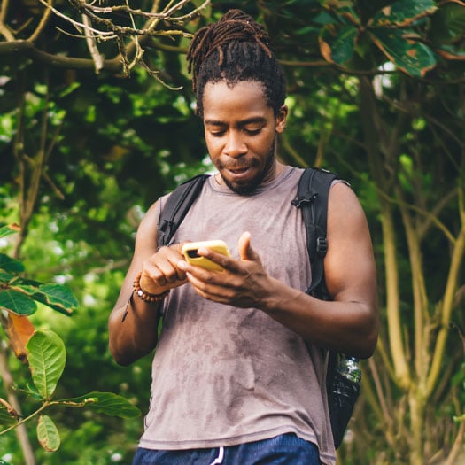 young man with backpack on his mobile phone