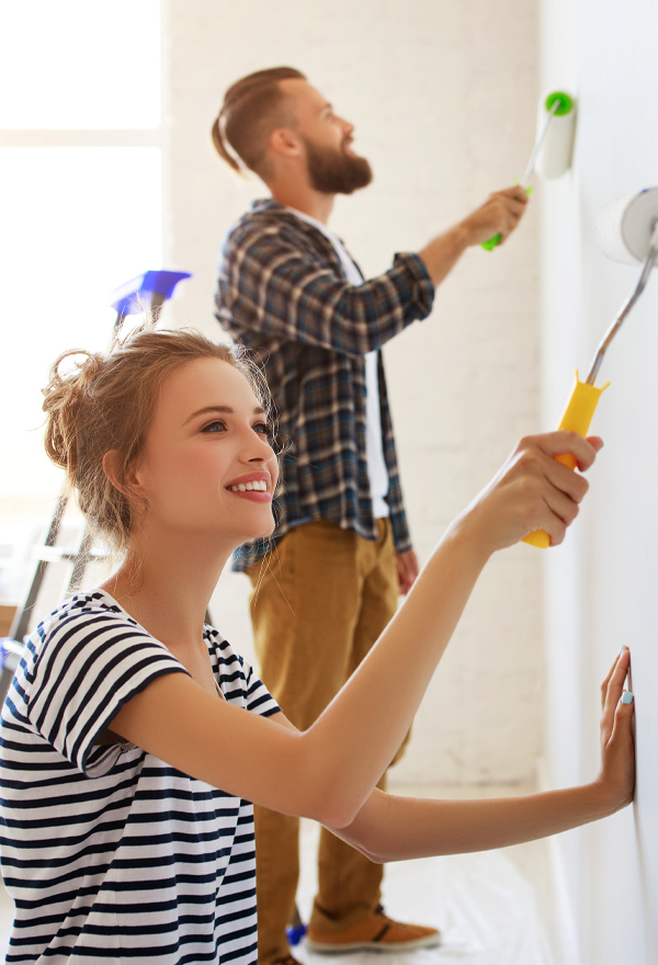 man and woman painting a white wall