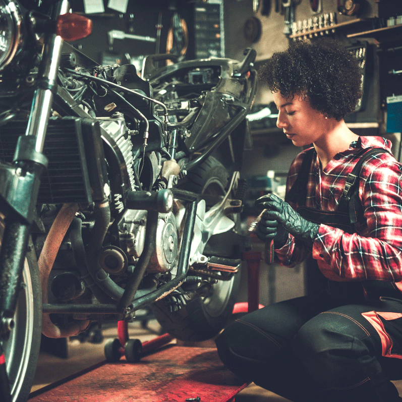 female mechanic fixing wrecked motorcycle