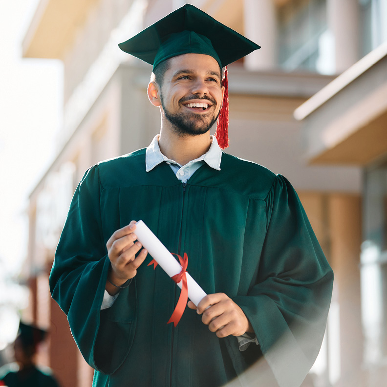 young man in cap and gown holding an degree