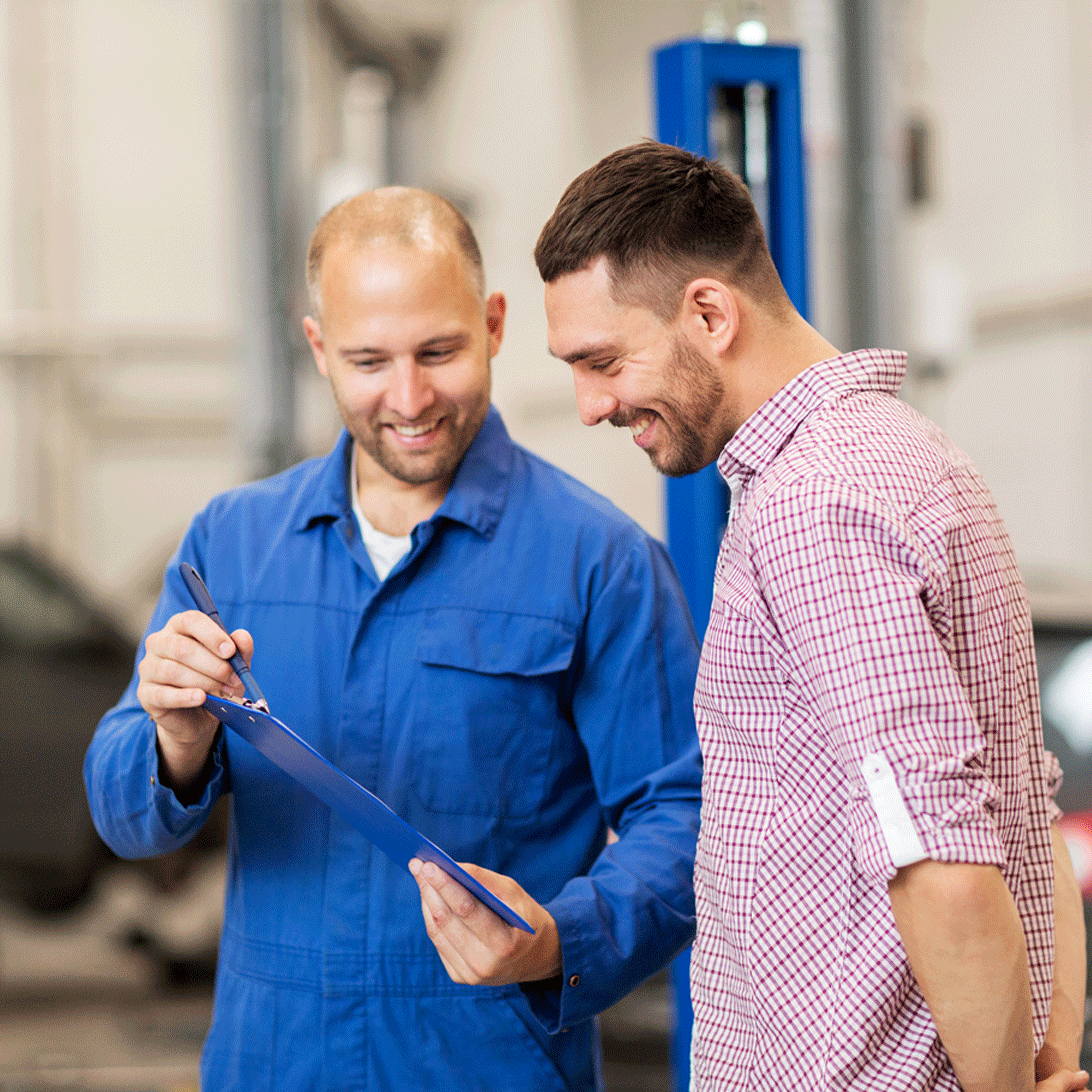 male mechanic showing a male customer his covered protection from his car warranty