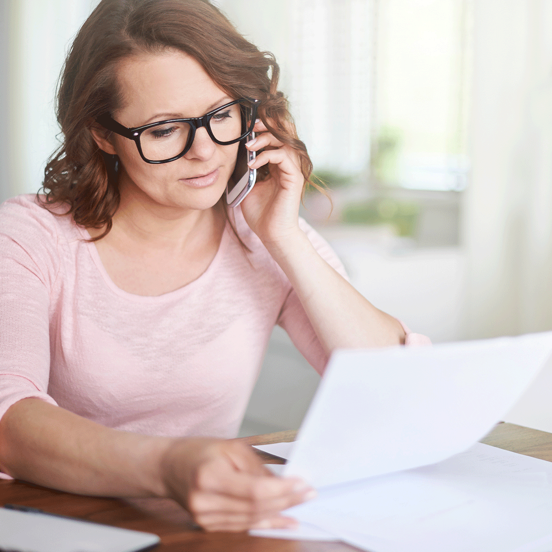 woman on mobile phone looking at her debt cancelation policy paperwork