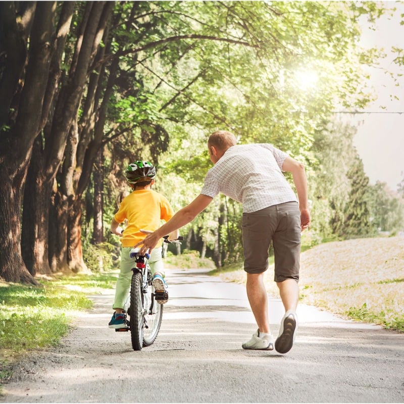 Dad-Helping-Kid-Ride-Bike