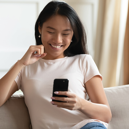 smiling teenage girl looking at her mobile phone