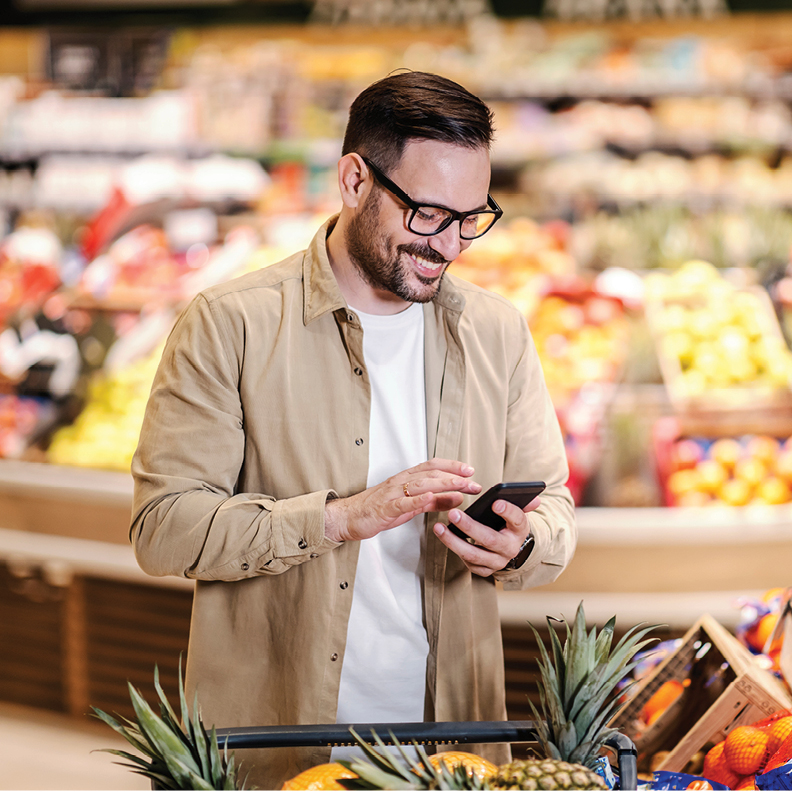 man checking his direct deposit on mobile phone in grocery store