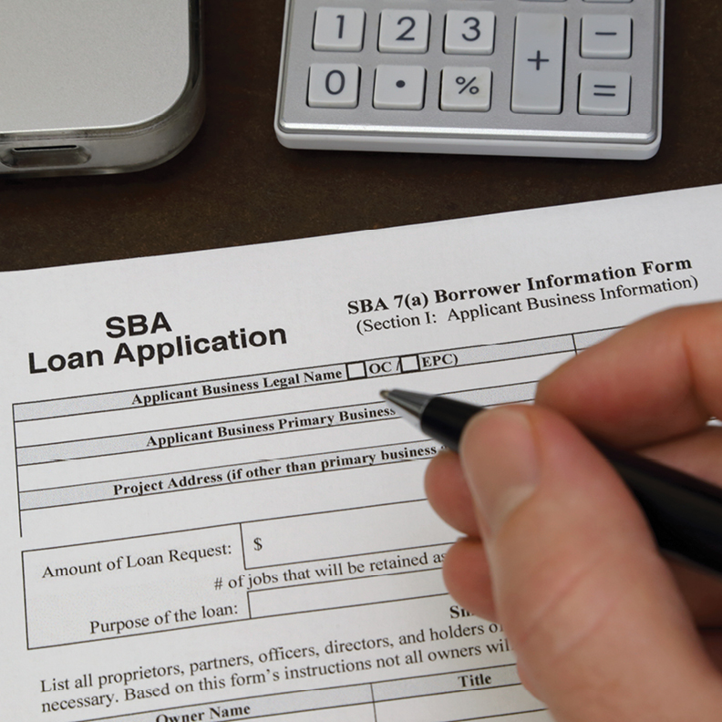close up of person filling out a small business administration loan application