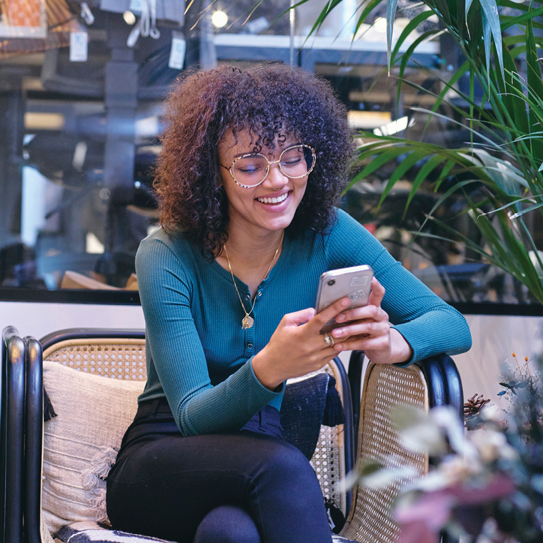 woman on mobile phone smiling at how easy it is to open a checking account online in Arizona 