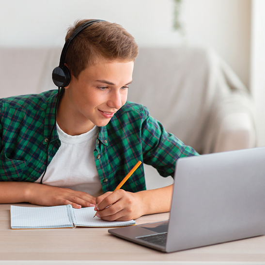 teenage boy with headphones doing homework