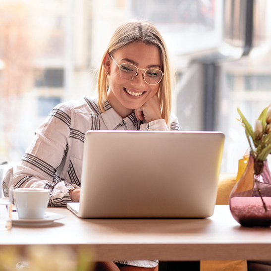 blonde girl with glasses on her laptop learning about ways to use a savings account