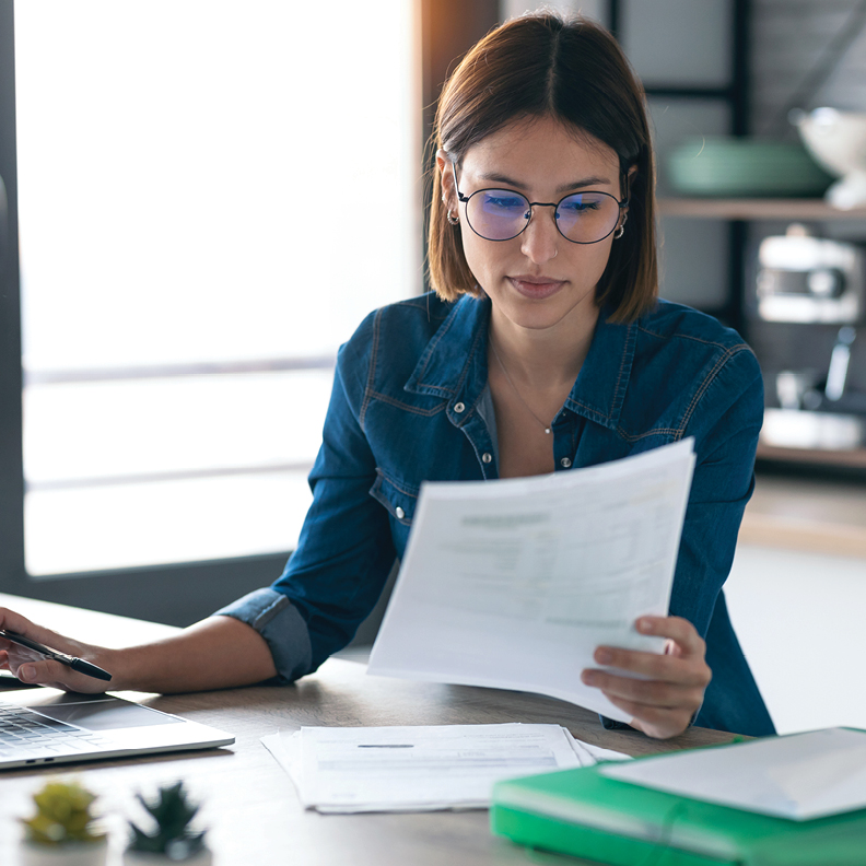 woman with glasses sitting and reading requirements for sba 504 loan