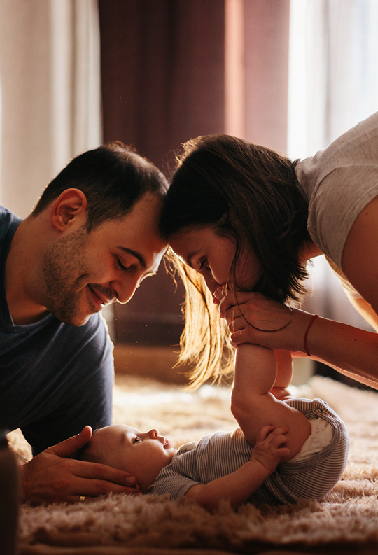 young parents on floor playing with baby 