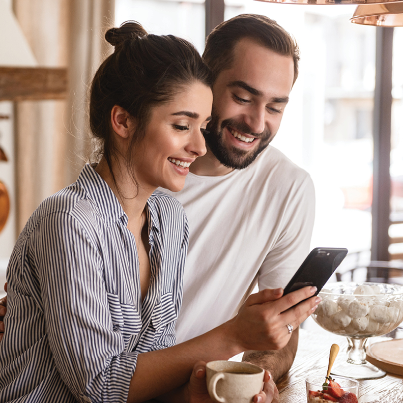 Smiling man and woman looking at phone