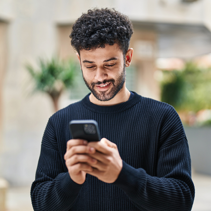Man smiling and looking at his phone