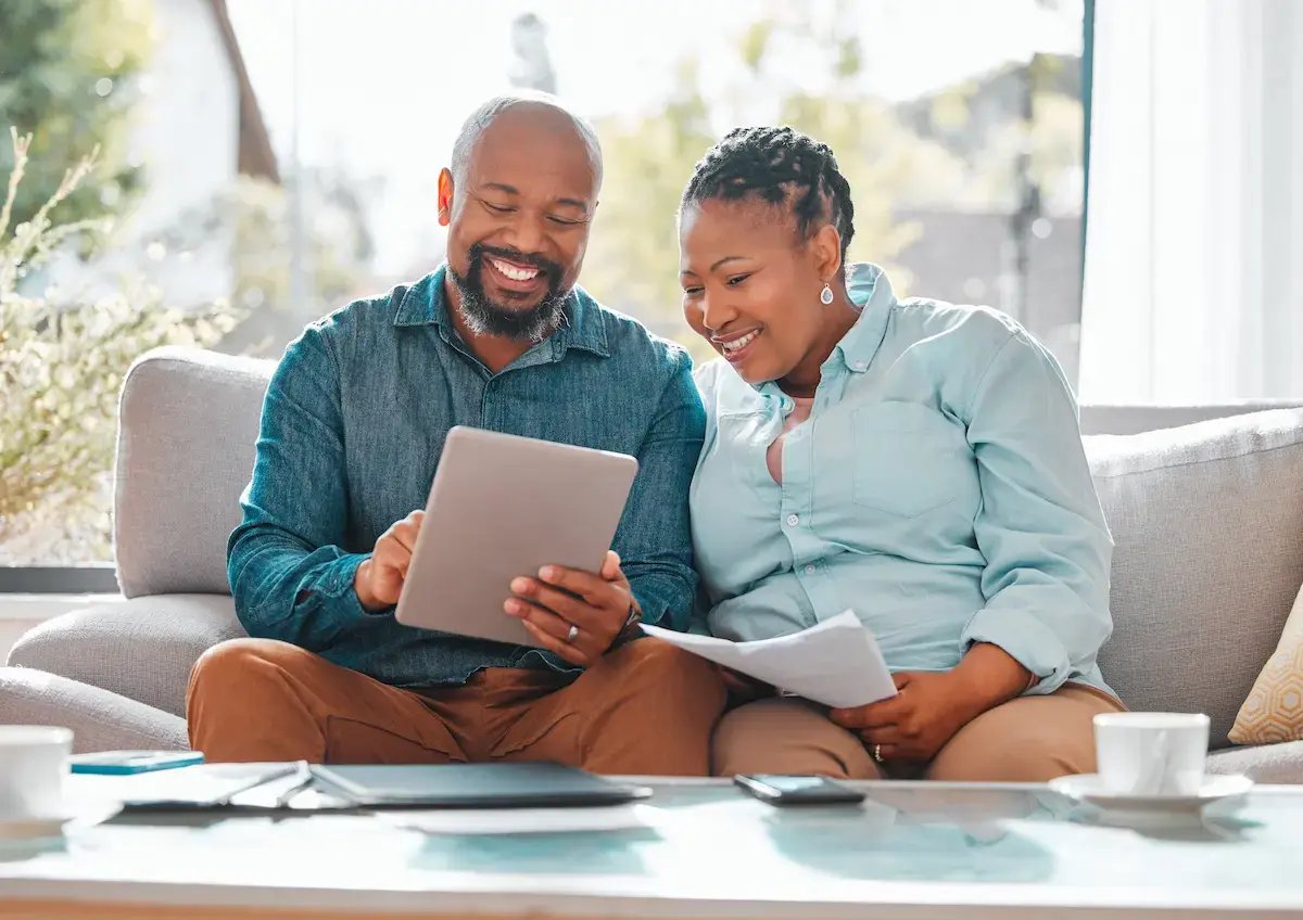 couple-smiling-and-looking-at-a-tablet