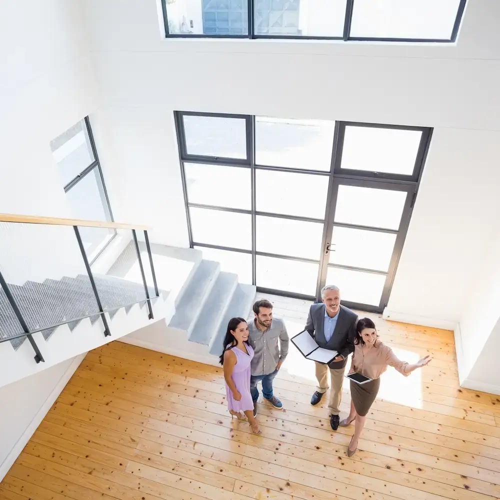 real-estate-agents-showing-a-new-house-to-a-young-couple