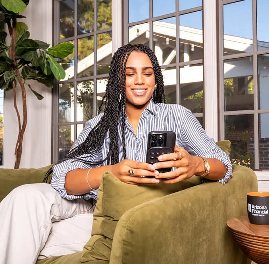 woman-looking-at-her-phone-and-smiling-while-opening-an-account