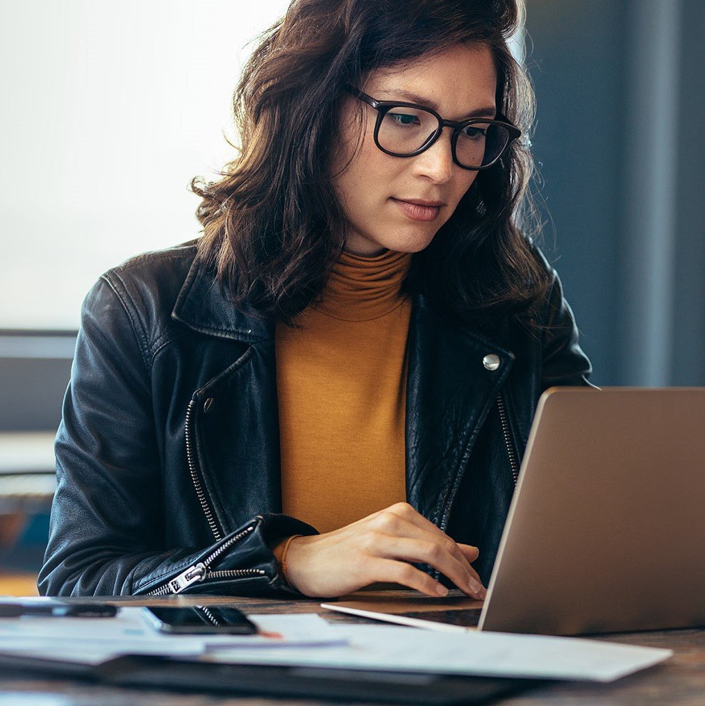 Woman with glasses using her laptop