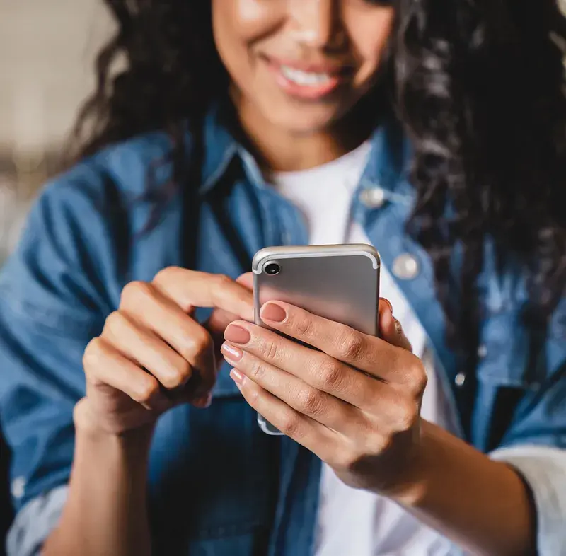 woman-smiling-while-filling-out-a-loan-application-on-her-phone